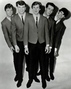 Jack Ely (center), former Kingsmen vocalist, know for his adequate singing talent and incessant "life isn't fair" whining